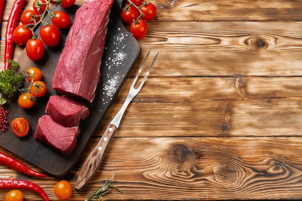 Kawałki surowego mięsa filet na desce drewnianej — Zdjęcie stockowe
