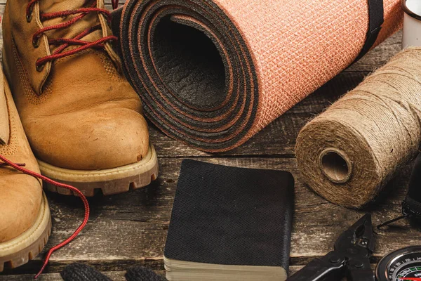 Wandelschoenen en touw hank op houten plank — Stockfoto