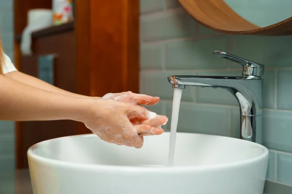 Nahaufnahme einer Frau, die sich in einem Waschbecken im Badezimmer die Hände wäscht — Stockfoto