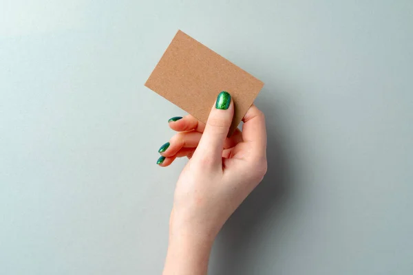 Kartka papieru rzemieślniczego w ręce kobiety izolowane na białym — Zdjęcie stockowe