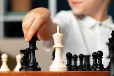 Satranç oynayan küçük bir çocuğun yakın plan fotoğrafı.