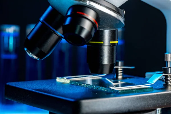 Microscope with lenses close up against dark background — Stock Photo, Image