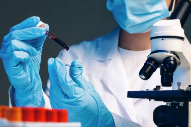 Kan testi yapan bir laboratuvar çalışanının elleri.