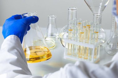 Laboratuvar örnekleriyle çalışan bir bilim adamının ellerine yakın çekim