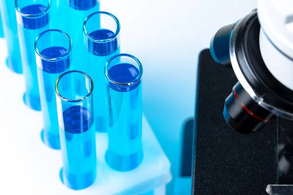 青色液体を用いた試験管のセットを用いた実験室用顕微鏡の閉鎖 — ストック写真