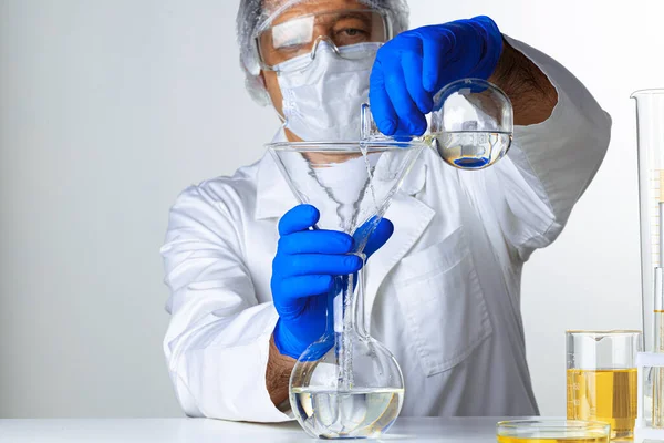 Naukowcy trzymają płyn w szklance w laboratorium do analizy. — Zdjęcie stockowe