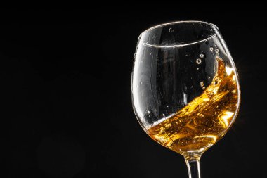 Siyah arka planda bir kadeh şarap, yakın plan.