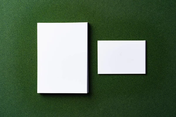 Στοίβες από λευκές επαγγελματικές κάρτες σε σκούρο πράσινο φόντο — Φωτογραφία Αρχείου