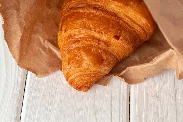 Tuore paistettu croissant puinen pöytä lähikuva — kuvapankkivalokuva