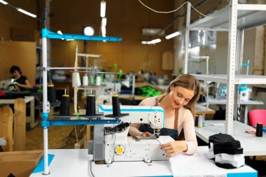 Güzel kadın terzi işyerinde kumaşla çalışıyor.