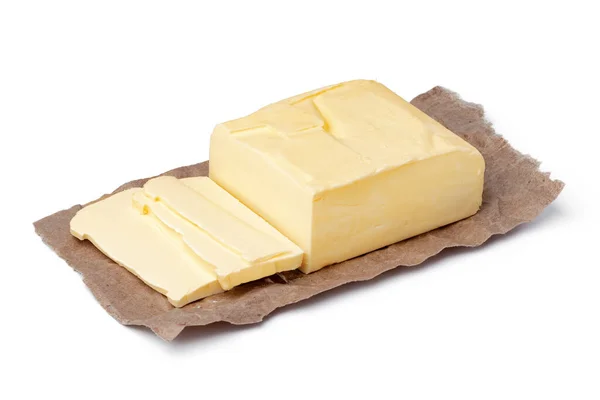 Čerstvé máslo na řemeslném papíru izolované na bílém pozadí — Stock fotografie