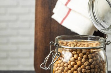 Cam kavanozda pişmemiş kurutulmamış nohutlar.