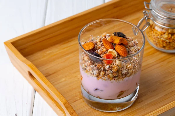 Leckeres Frühstück mit Müsli, Joghurt und Früchten in einer Glasschüssel — Stockfoto