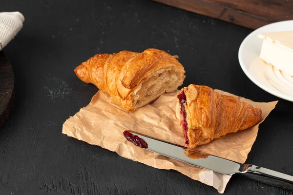Fresh croissants with berry jam on dark wooden board — Stock Photo, Image