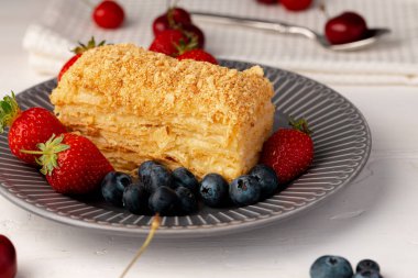 Bir parça Rus ballı keki Medovik böğürtlenlerle servis edilir.