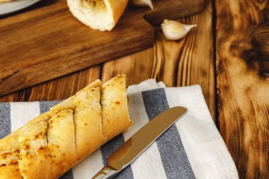 Sarımsak yağı ve bitkilerle dilimlenmiş taze baget.