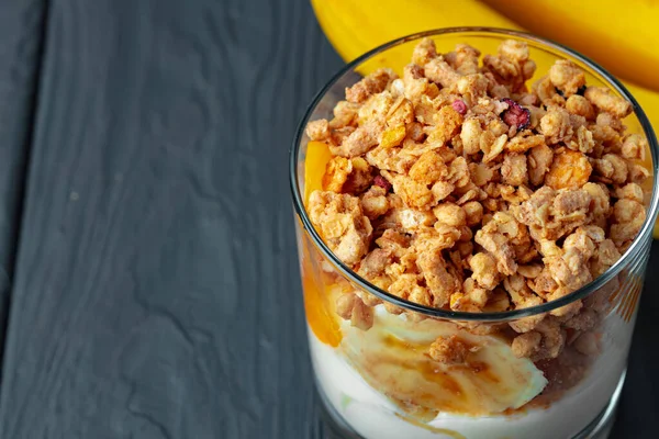 Bom café da manhã com granola, iogurte e frutas em uma tigela de vidro — Fotografia de Stock