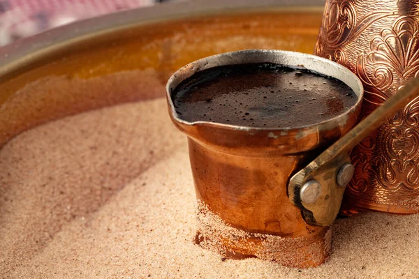 Copper turk with coffee brewing in sand — Stock Photo, Image