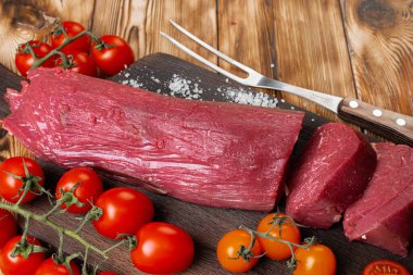 Tahtada çiğ et filetosu dilimler.