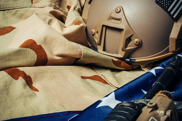 Bandera de batalla estadounidense y rifle de asalto en la mesa de madera . — Foto de Stock