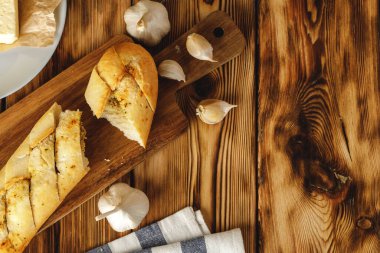 Sarımsak yağı ve bitkilerle dilimlenmiş taze baget.