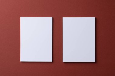 Burgundy kağıt arka planında boş beyaz kartvizitler