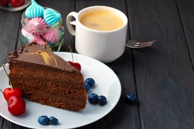 Taze böğürtlenlerle servis edilen bir parça çikolatalı kek.