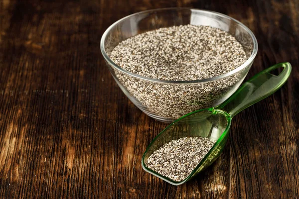 Tigela de vidro com sementes de chia na mesa de madeira — Fotografia de Stock