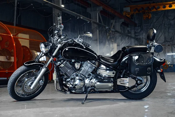 Motorrad steht in einem dunklen Hangargebäude — Stockfoto