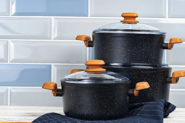 Novos utensílios de cozinha preto com alças de madeira de perto — Fotografia de Stock