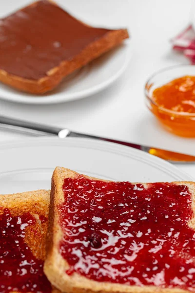 Хрусткі тости, покриті фруктовим джемом, подаються на кухонному столі — стокове фото