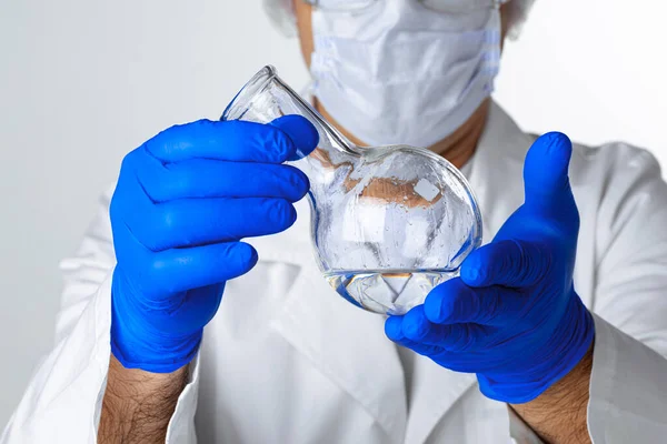 A tudósok kezei, amint folyadékot tartanak egy üvegben a laboratóriumban elemzésre. — Stock Fotó