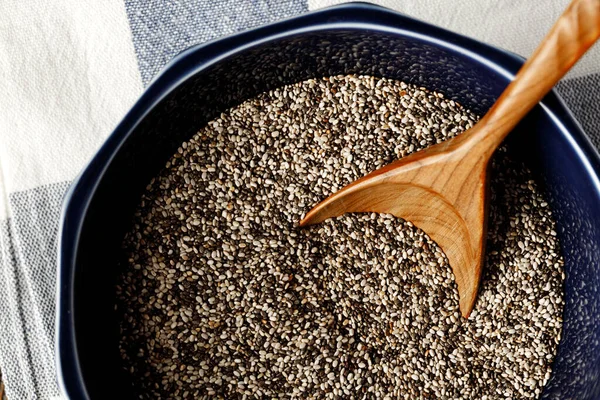 Chia seeds in a bowl with wooden spoon — Stock Photo, Image