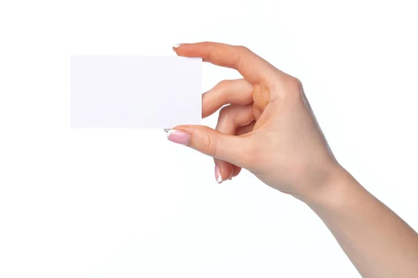 Bela mão feminina segurando cartão de visita branco no fundo branco — Fotografia de Stock