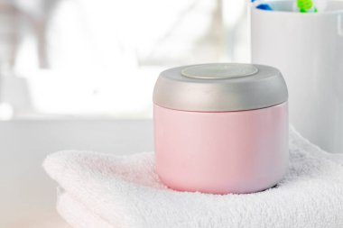 Beyaz banyo duvarına dayanan kozmetik şişeler