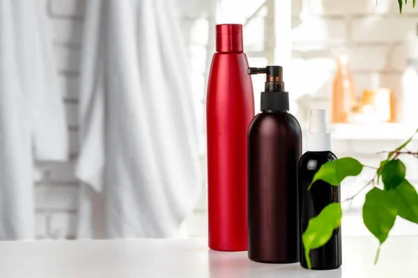 Botellas cosméticas contra fondo de pared de baño blanco — Foto de Stock
