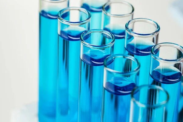 Laboratoryjne probówki z niebieskim płynem zamykającym — Zdjęcie stockowe
