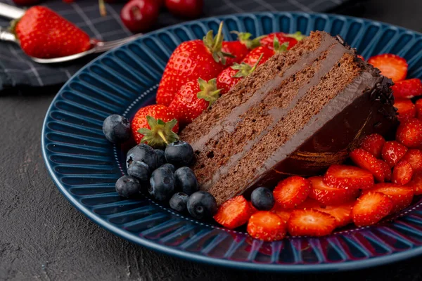Шматочок смачного шоколадного торта з нарізаною полуницею — стокове фото