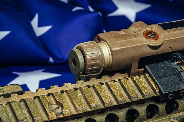 木製のテーブルにアメリカの戦闘旗とアサルトライフル. — ストック写真