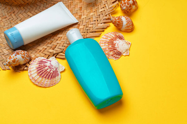 Пляжная шляпа и бутылка солнцезащитного крема. Концепция отдыха