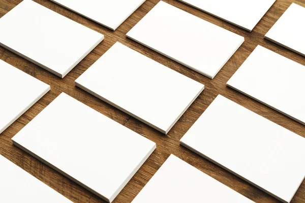 Montones de tarjetas de visita en blanco en la mesa de madera áspera — Foto de Stock
