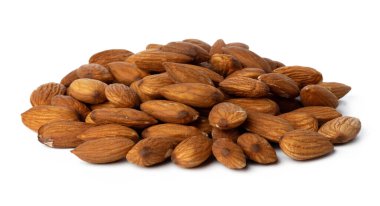 Beyaza izole edilmiş kavrulmuş badem yığını.