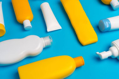 Mavi arka planda güneş kremi şişeleri