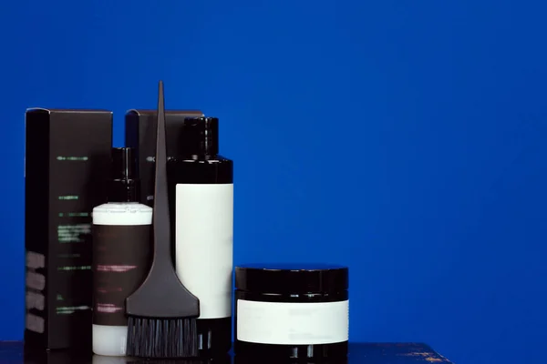Hårfärg kosmetiska produkter i svarta förpackningar med kopieringsutrymme — Stockfoto