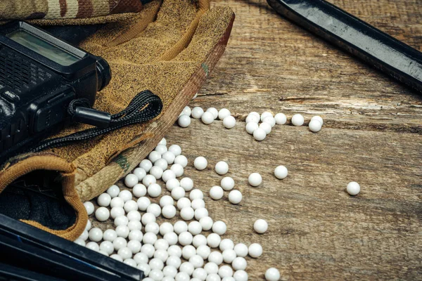 Detailní záběr airsoft pistole zásobníku a airsoft koule na dřevěném pozadí — Stock fotografie