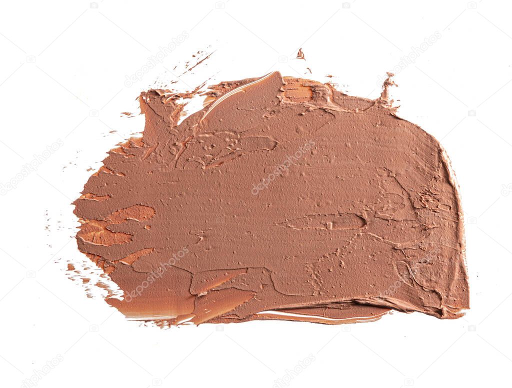 Smears of dark cream cosmetic foundation isolated on white