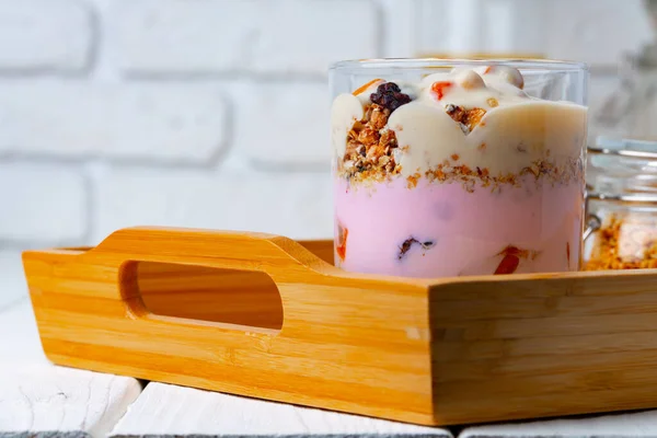 Bom café da manhã com granola, iogurte e frutas em uma tigela de vidro — Fotografia de Stock