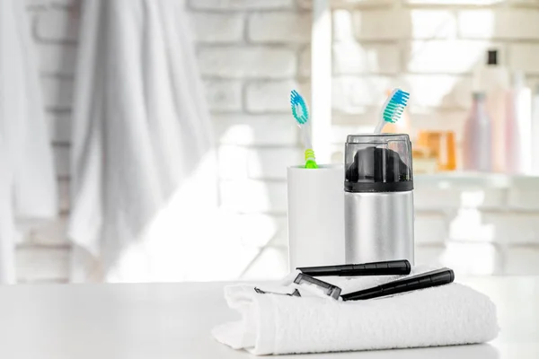 White cup with toothbrushes and towels in bathroom — Stock Photo, Image