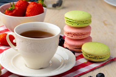 Renkli kurabiyelerle bir fincan kahve yakın.