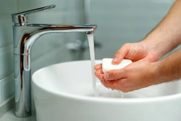 Закрыть фотографию мужских рук, моющихся с мылом над раковиной — стоковое фото